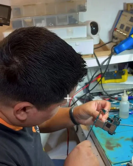 Técnico consertando um celular na bancada de reparos
